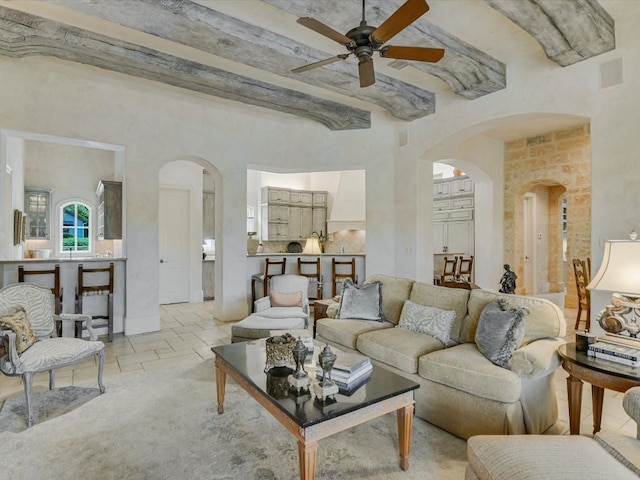 living room featuring light tile patterned flooring, beam ceiling, and ceiling fan