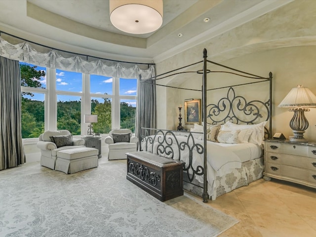 bedroom with a raised ceiling and tile patterned floors