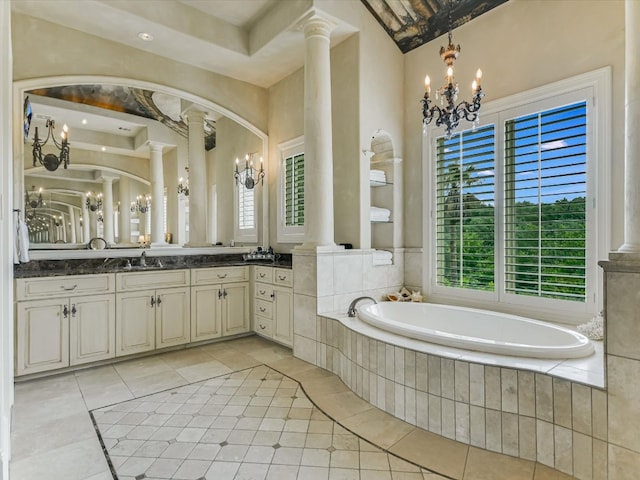 bathroom with tiled tub, vanity, plenty of natural light, and decorative columns