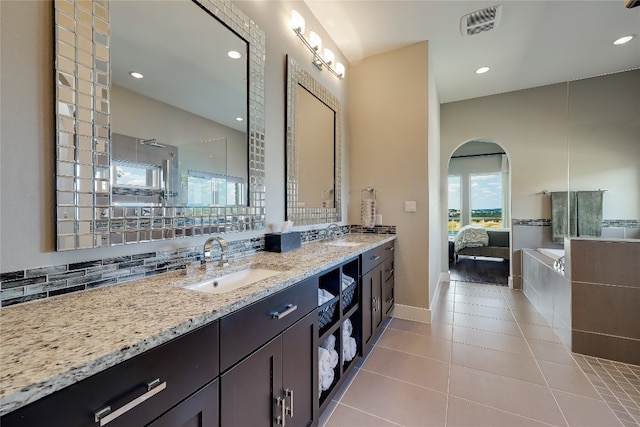 bathroom with tile patterned floors, a shower, vanity, and backsplash