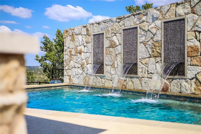 view of swimming pool with pool water feature