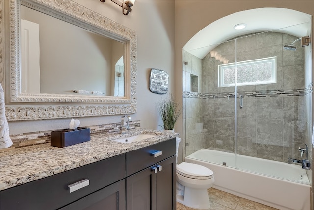 full bathroom featuring enclosed tub / shower combo, vanity, toilet, and tile patterned floors