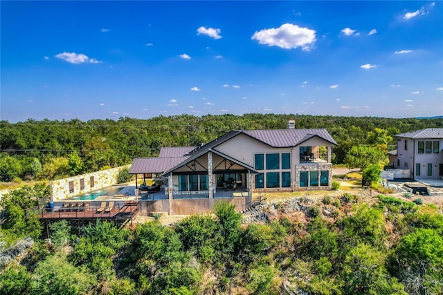 rear view of property with a pool