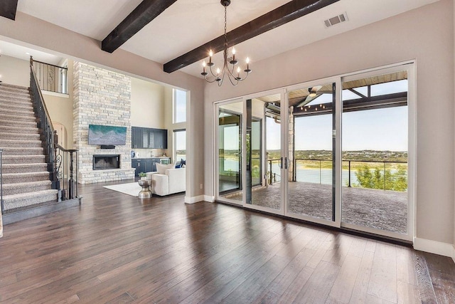 1612 Watercliffe Dr, Lago Vista, TX 78645 - living area featuring wood-type flooring, beamed ceiling, baseboards, stairway, and a fireplace