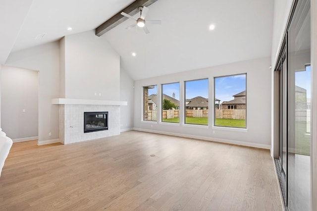 105 Bull Ridge Trl, Georgetown, TX 78628 - unfurnished living room with beam ceiling, high vaulted ceiling, baseboards, light wood-type flooring, and a tiled fireplace