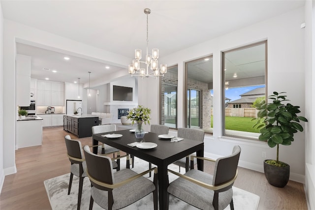 dining room featuring sink, light hardwood / wood-style floors, and a chandelier