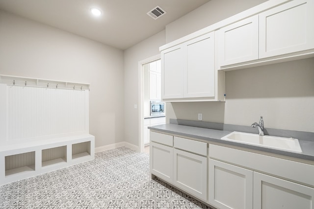 interior space featuring sink and white cabinetry