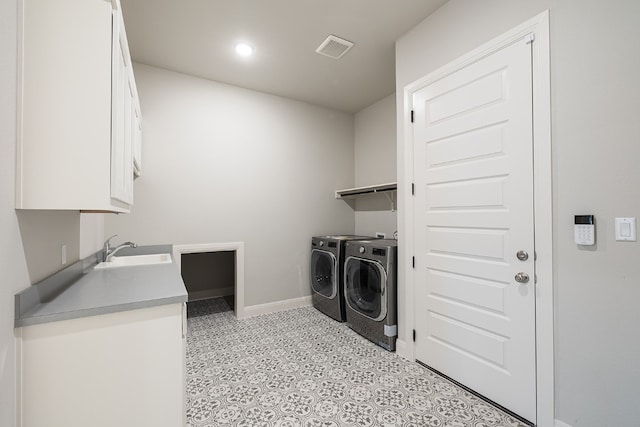 washroom with cabinets, sink, and independent washer and dryer