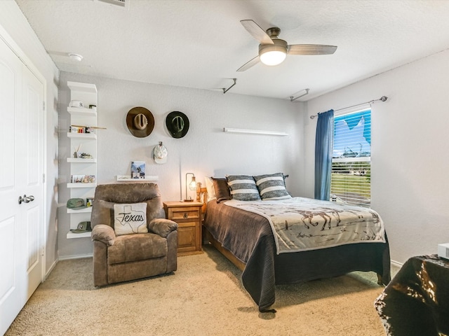 carpeted bedroom featuring a textured ceiling, ceiling fan, and a closet