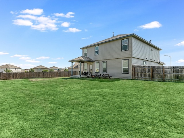 rear view of property with a lawn and a patio