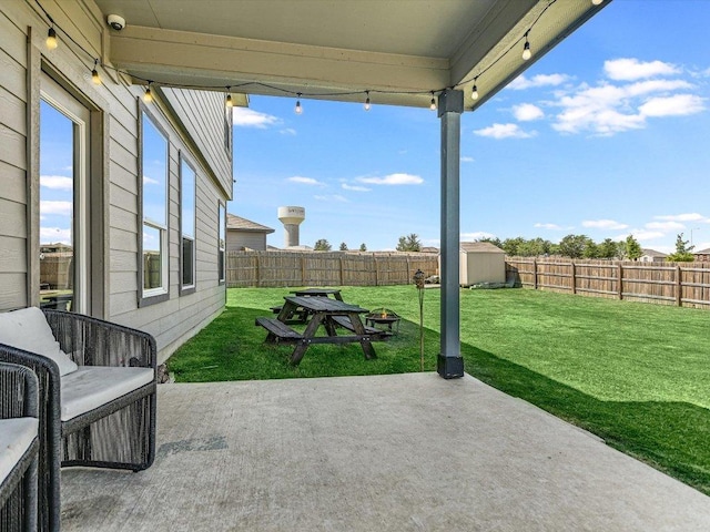 view of patio / terrace with a fenced backyard, a storage unit, and an outdoor structure