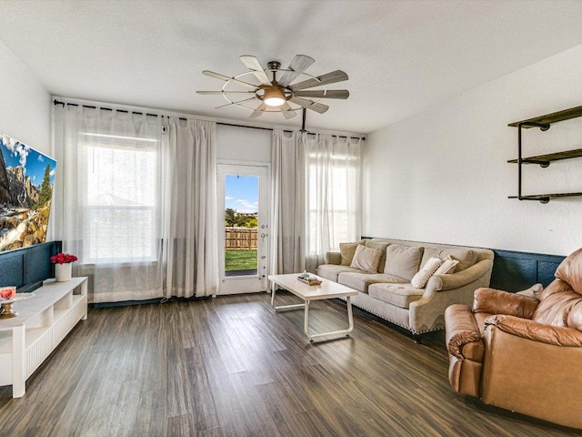 living area with dark wood-type flooring and ceiling fan