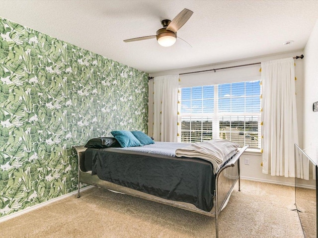 carpeted bedroom with wallpapered walls, baseboards, a textured ceiling, and ceiling fan