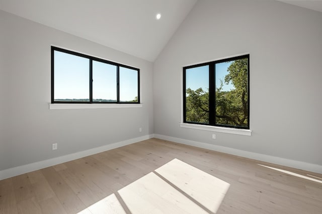 empty room featuring light hardwood / wood-style floors and high vaulted ceiling