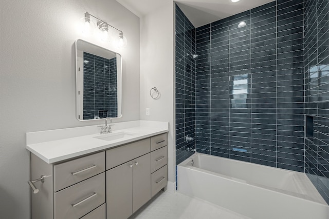 bathroom featuring tiled shower / bath combo and vanity