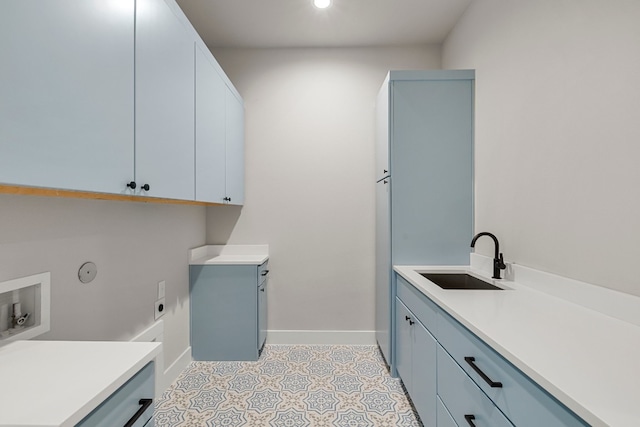 clothes washing area featuring washer hookup, light tile patterned floors, cabinets, and sink