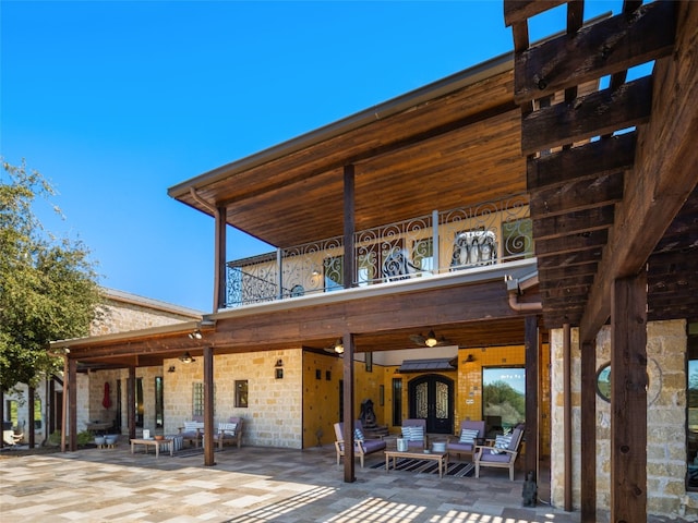 rear view of house featuring an outdoor living space and a patio area