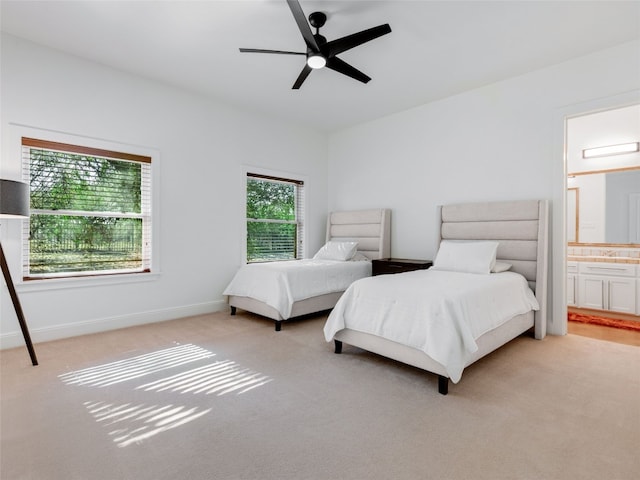 bedroom with ensuite bath, ceiling fan, and light colored carpet