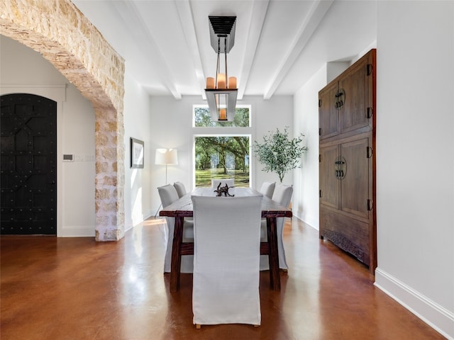 dining space with beamed ceiling