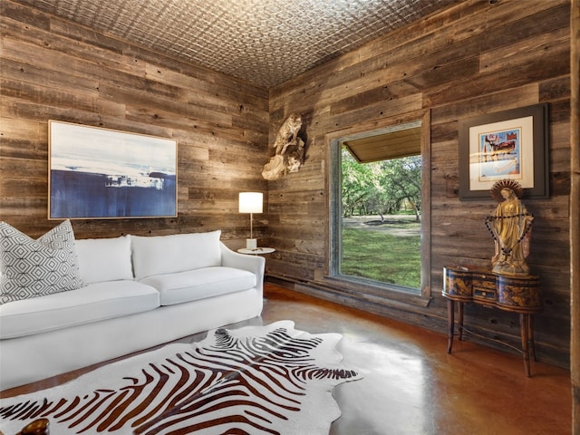 living room featuring wooden walls and concrete flooring