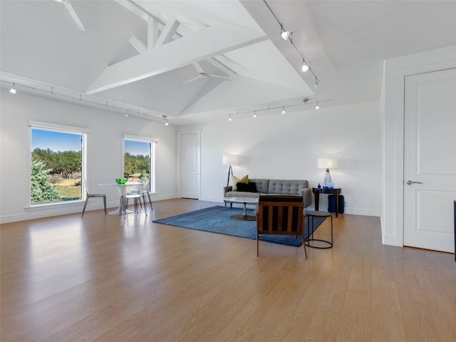 living room featuring high vaulted ceiling, beam ceiling, light hardwood / wood-style floors, and rail lighting