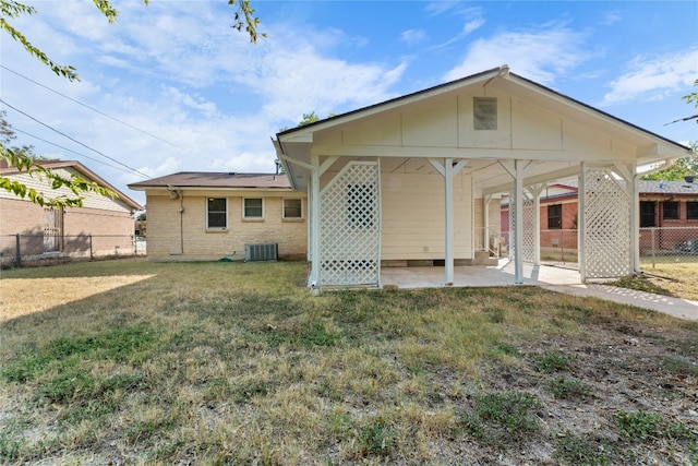 rear view of house with a patio area, cooling unit, and a lawn