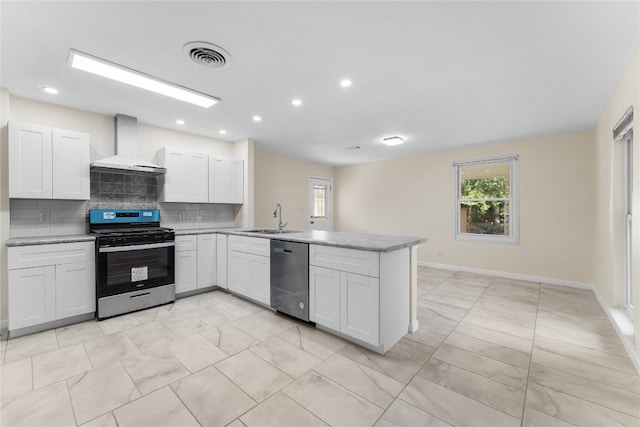 kitchen with wall chimney range hood, kitchen peninsula, decorative backsplash, appliances with stainless steel finishes, and white cabinetry