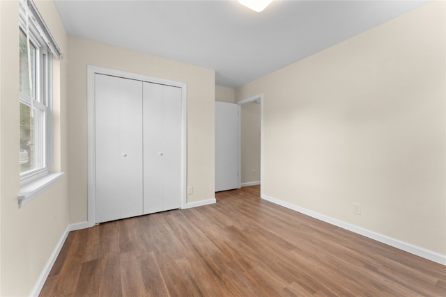 unfurnished bedroom with light hardwood / wood-style flooring and a closet