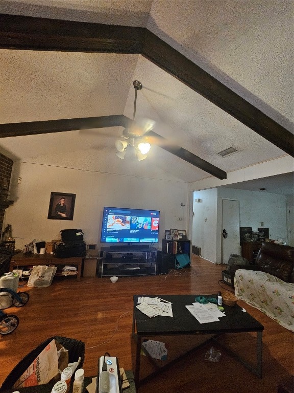 living room with a textured ceiling, vaulted ceiling with beams, hardwood / wood-style floors, and ceiling fan