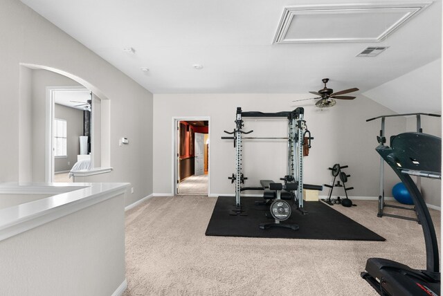 exercise room with ceiling fan, light colored carpet, and vaulted ceiling