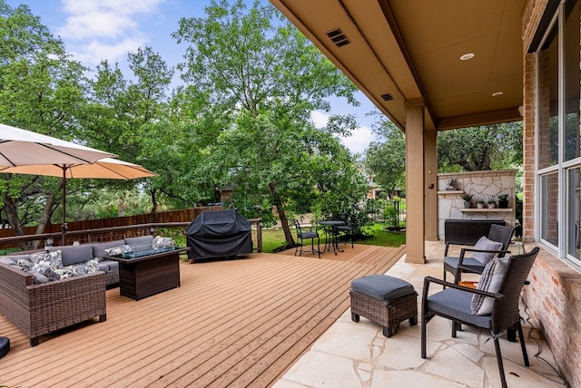 wooden deck with grilling area and an outdoor living space