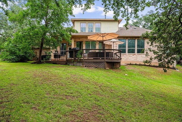 rear view of house with a wooden deck and a yard