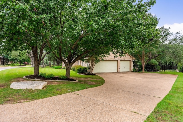 3109 Wild Rock Cv, Austin, TX 78732 - view of property hidden behind natural elements with concrete driveway, an attached garage, fence, and a front yard
