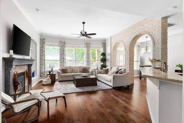 living room featuring crown molding, ceiling fan, and dark hardwood / wood-style flooring