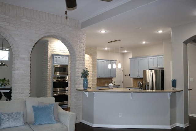 kitchen featuring appliances with stainless steel finishes, white cabinets, ceiling fan, and kitchen peninsula