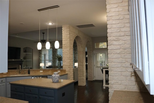 kitchen featuring sink, hanging light fixtures, dark hardwood / wood-style floors, a center island, and stainless steel dishwasher