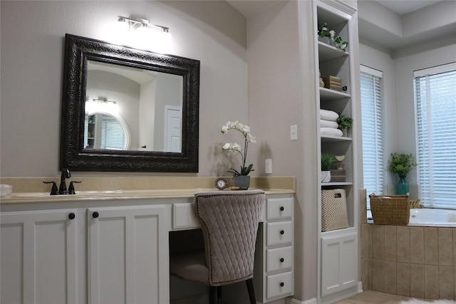 bathroom with vanity and tiled tub