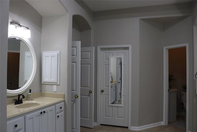 bathroom featuring vanity, tile patterned floors, and toilet