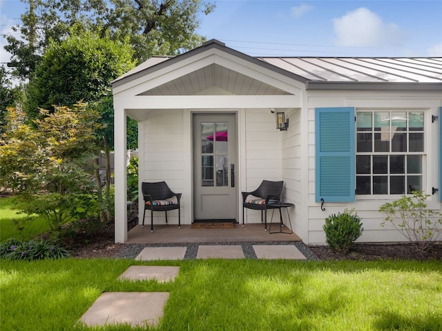 view of exterior entry featuring a lawn