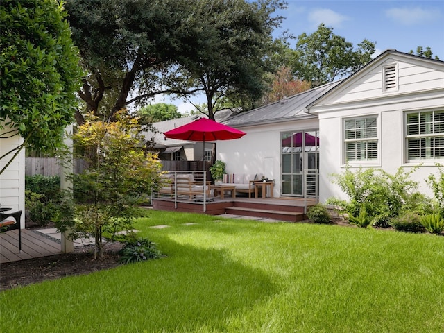 rear view of property featuring a deck and a lawn