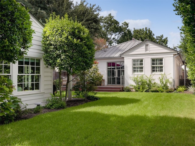 rear view of property with a lawn