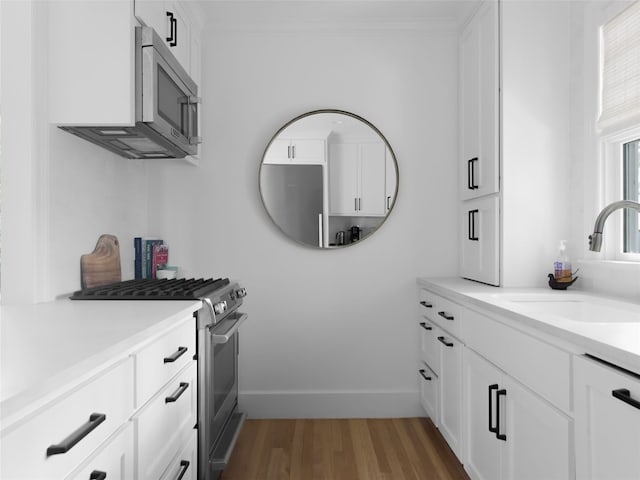 bathroom featuring wood-type flooring, vanity, and crown molding