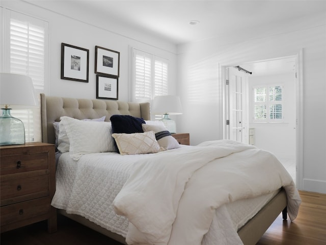 bedroom featuring wood-type flooring and multiple windows