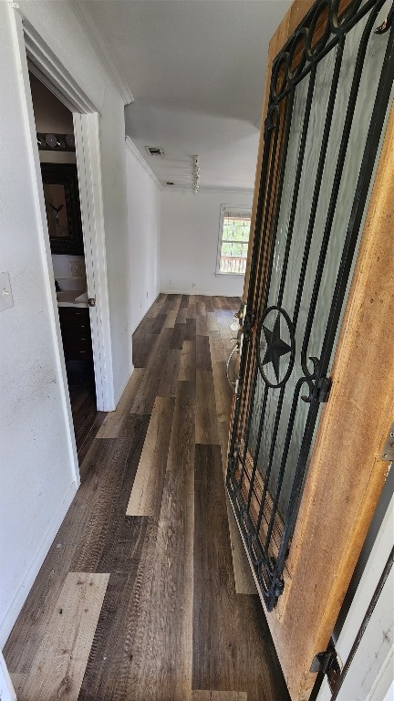 corridor with dark hardwood / wood-style floors and ornamental molding