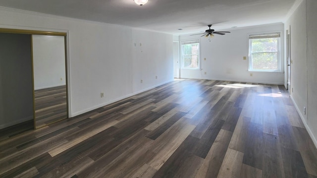 spare room featuring dark wood-type flooring, ceiling fan, and a healthy amount of sunlight