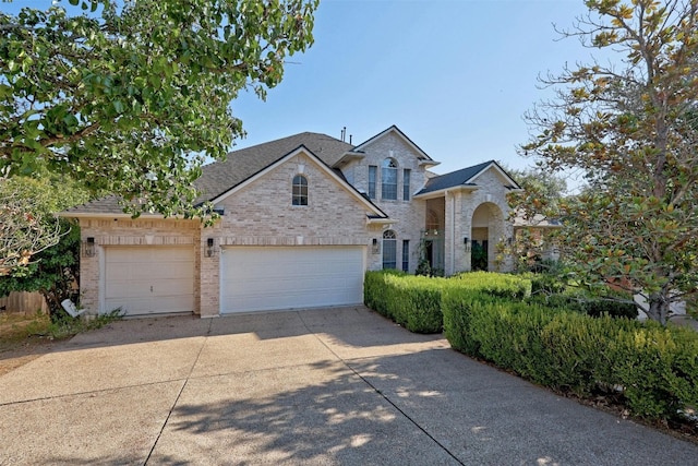 9228 Limoncillo Dr, Austin, TX 78750 - view of front of house with concrete driveway, brick siding, an attached garage, and a shingled roof