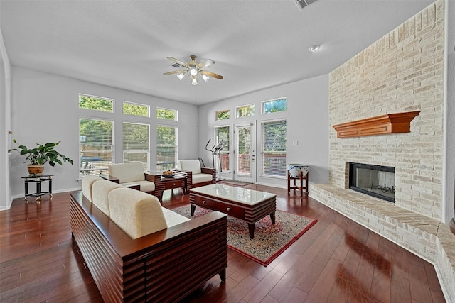 living room with a fireplace, dark hardwood / wood-style floors, and ceiling fan