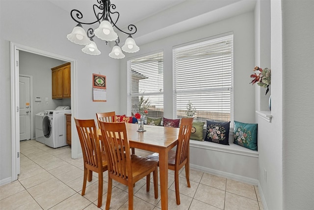 dining space featuring washing machine and clothes dryer, a chandelier, and light tile patterned floors