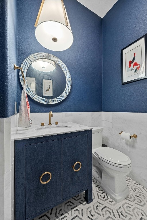 bathroom featuring tile walls, tile patterned flooring, vanity, and toilet