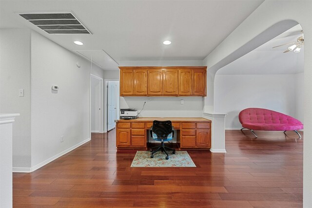 office featuring ceiling fan, built in desk, and dark wood-type flooring